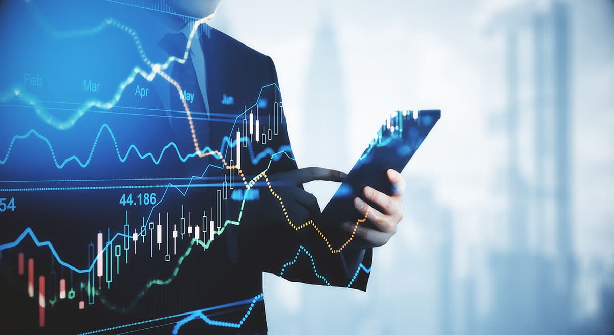 Trading and investment concept trader silhouette with digital tablet and virtual screen with financial chart graphs and candlestick